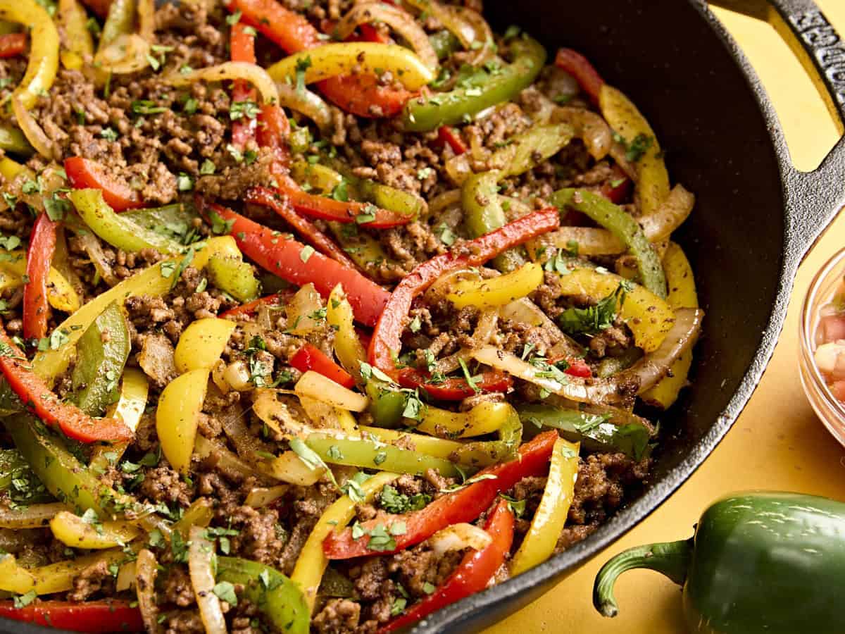 A close up of a skillet of beef fajitas.