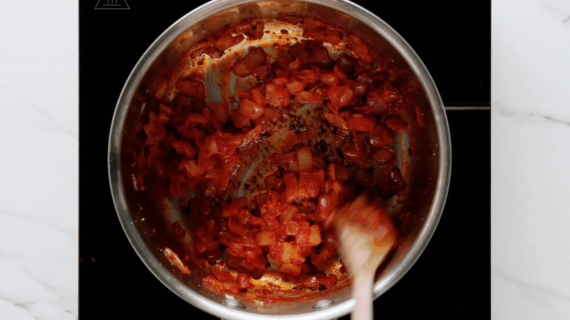 adding seasonings to meatball red sauce