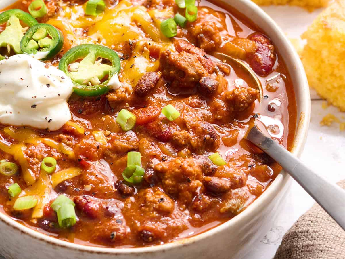 homemade chili in a bowl with a spoon serving it up