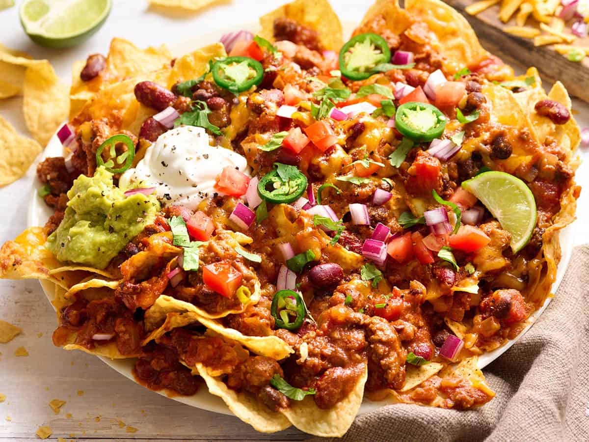 Homemade chili on nachos with guacamole, sour cream, jalapenos and red onions