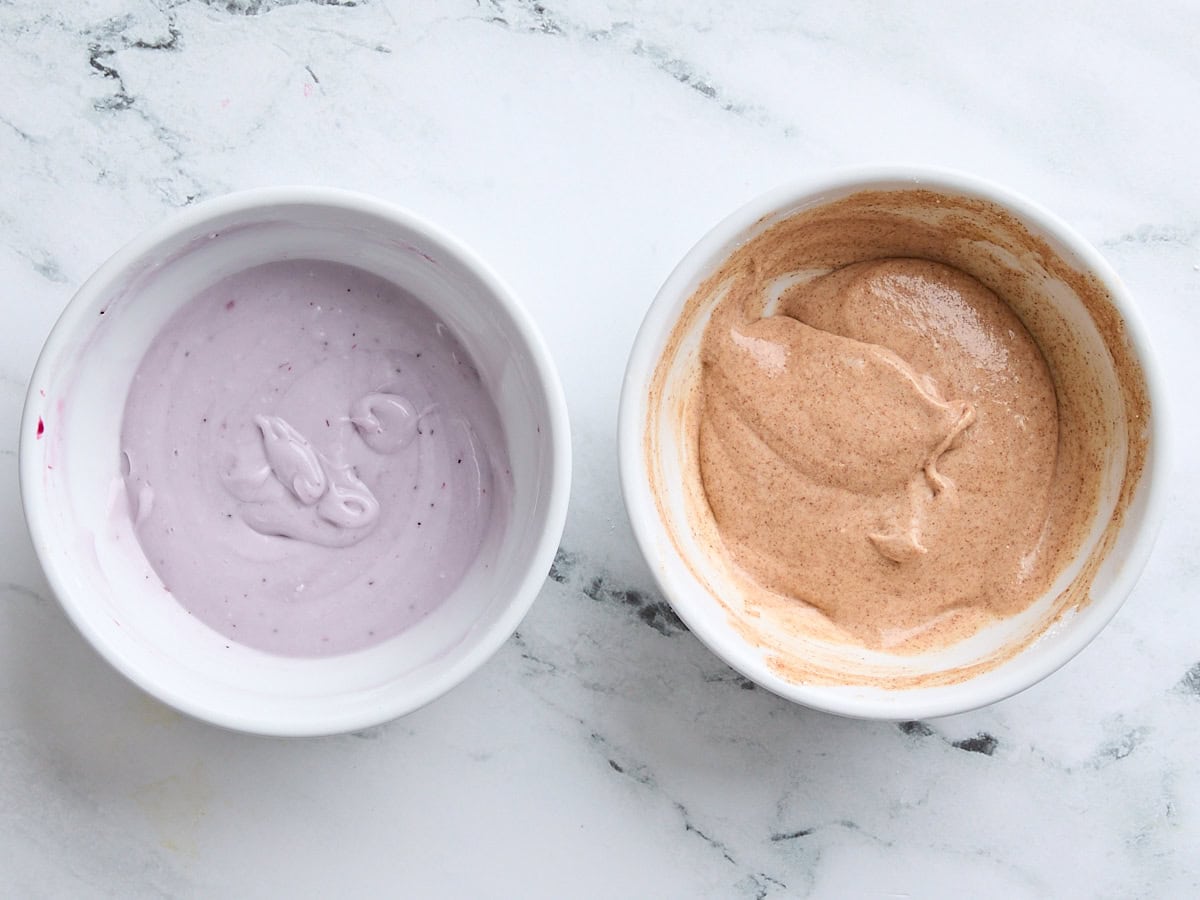 Berry frosting in a bowl and cinnamon sugar frosting in a bowl.