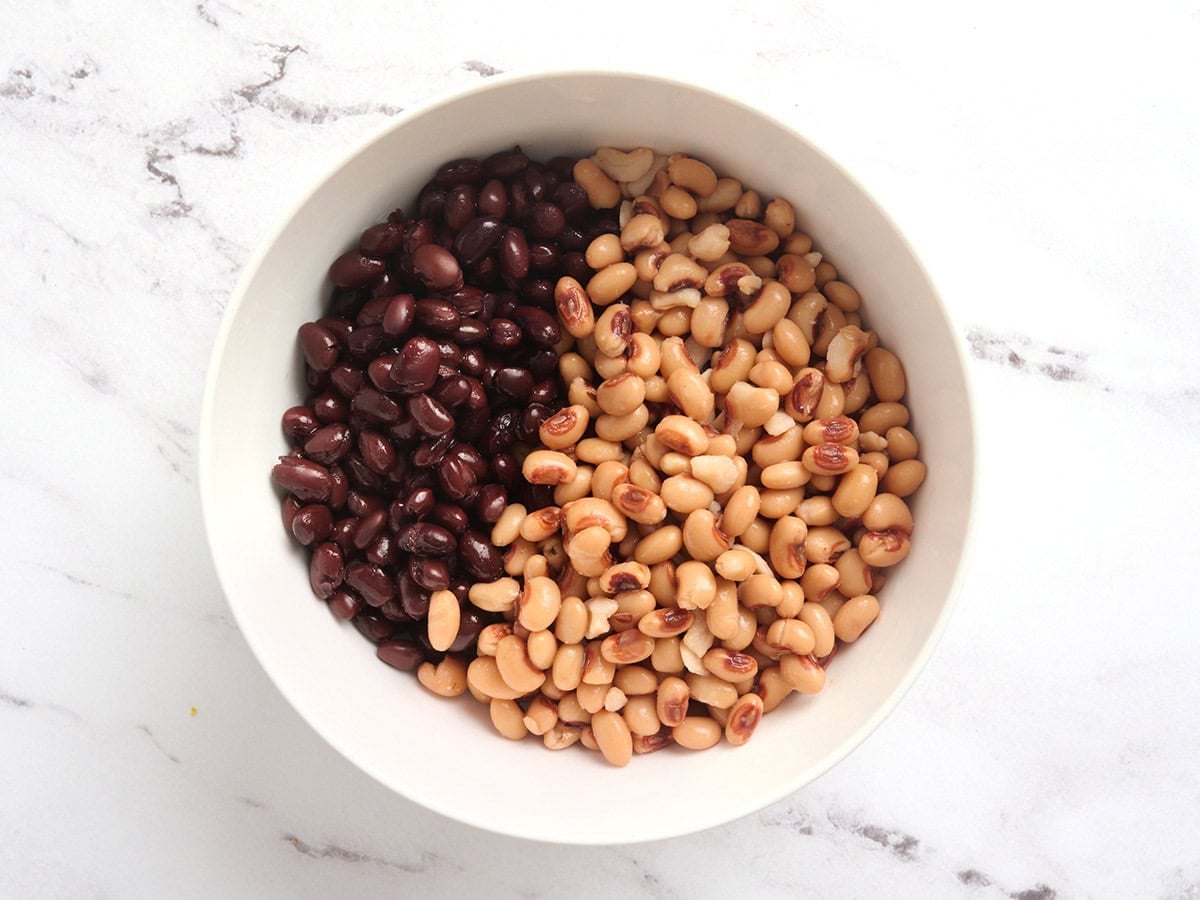 Black eyes peas and black beans in a mixing bowl.