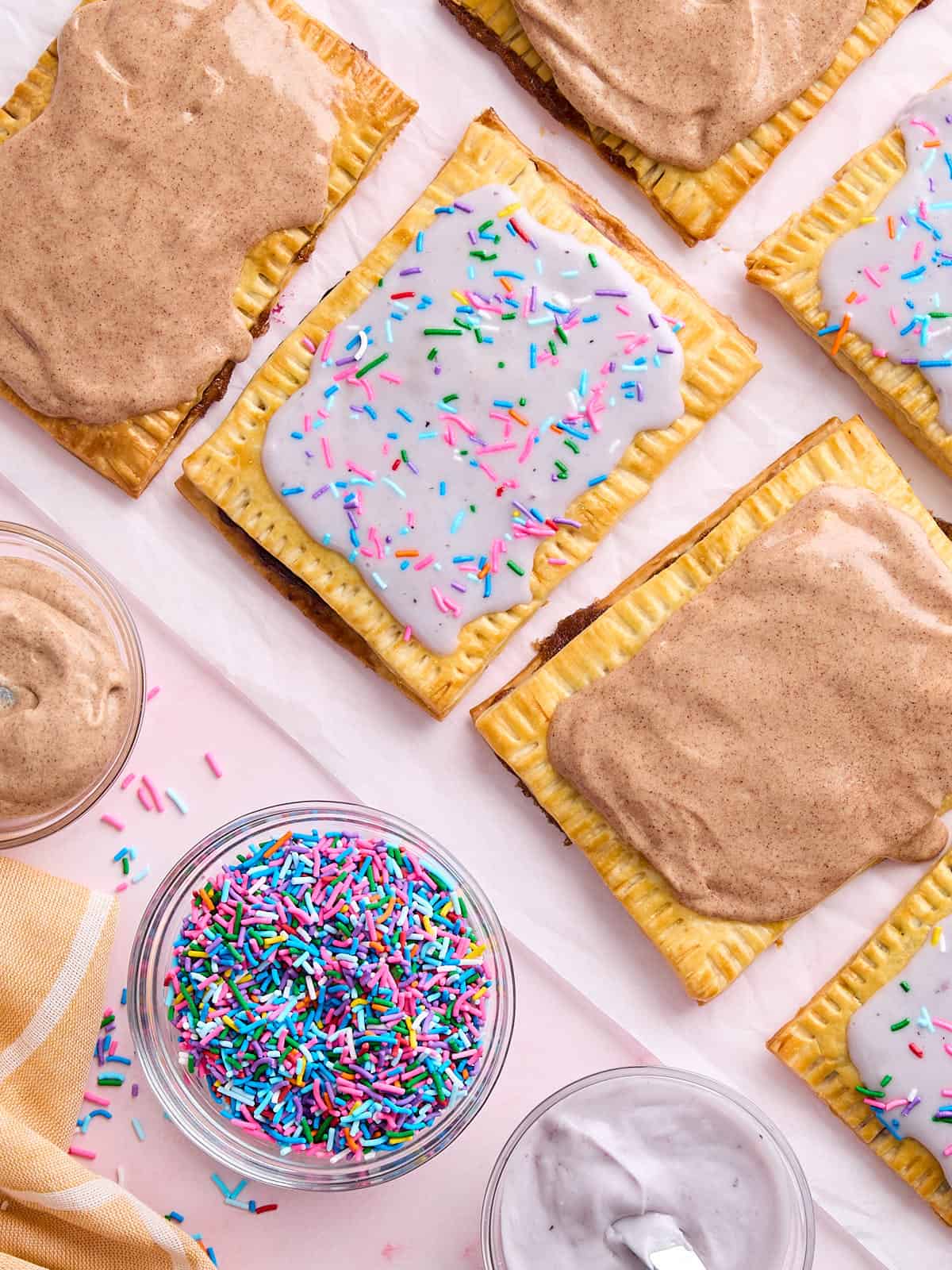 Overhead view of homemade pop tarts next to a bowl of sprinkles.