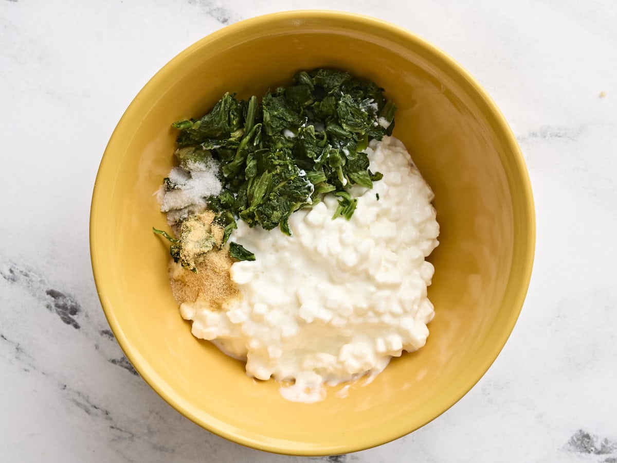 Cottage cheese, chopped thawed spinach and seasonings in a bowl.