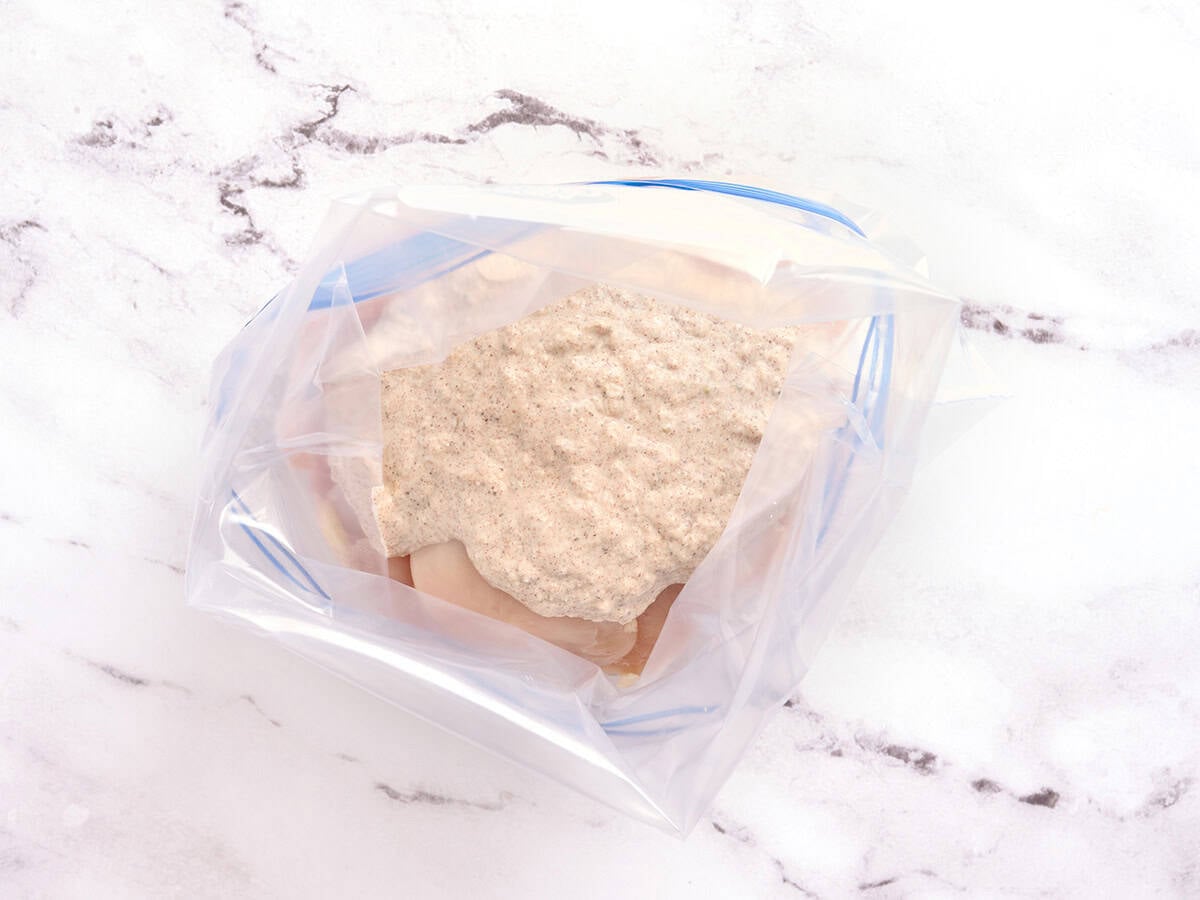 Chicken breast marinating in a ziptop bag.