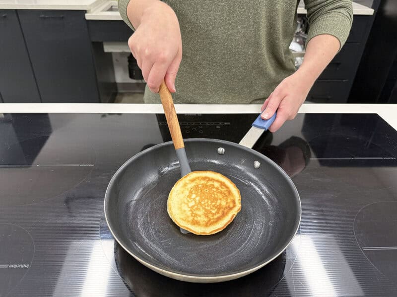 woman making fluffy pancakes in a skillet