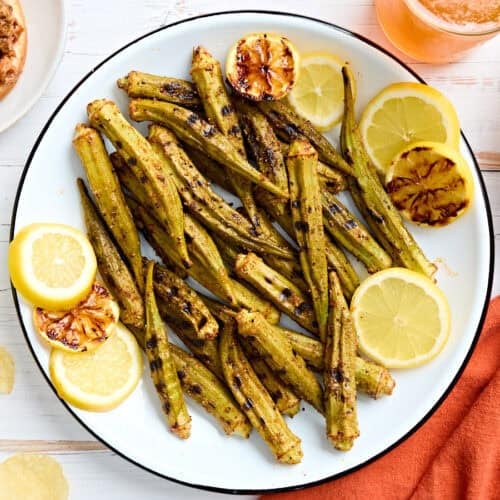 Aerial view of grilled Gombo on a plate with lemon slices.