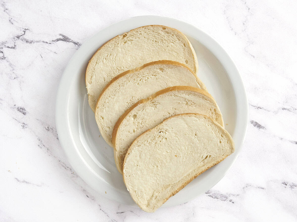 Four slices of sourdough topped with butter.