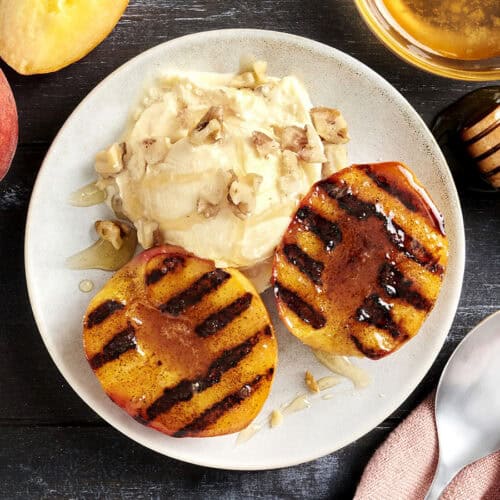 Overhead view of a bowl of grilled peaches and ice cream.
