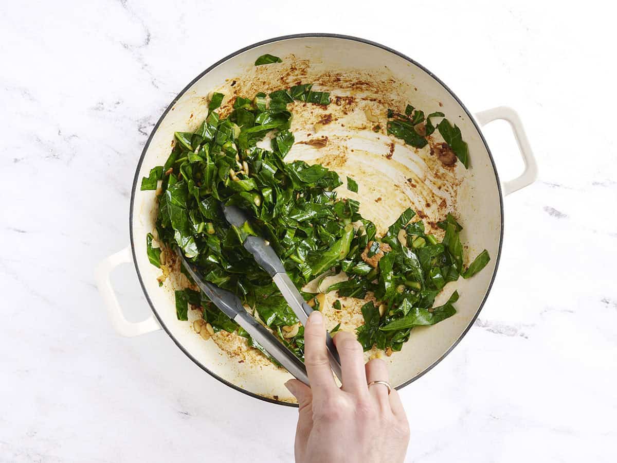 Cooked collard greens with garlic in a skillet.