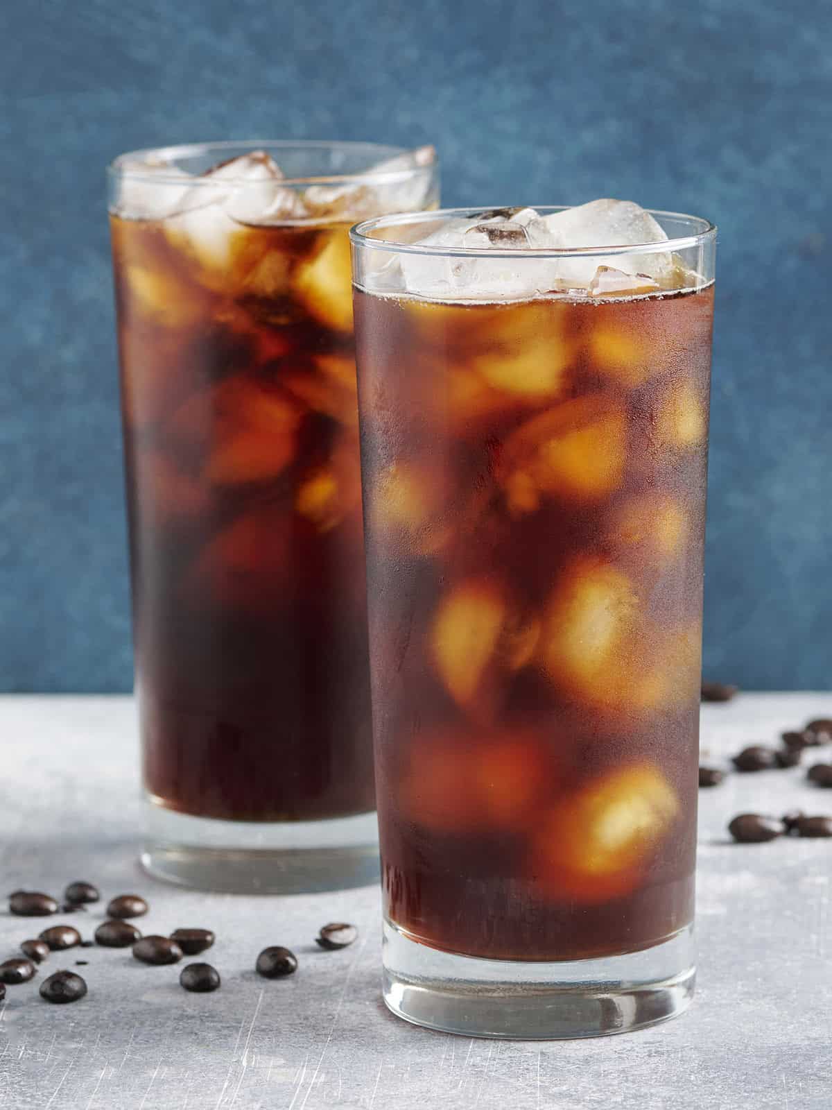 Side view of two glassed of cold brew coffee with ice.