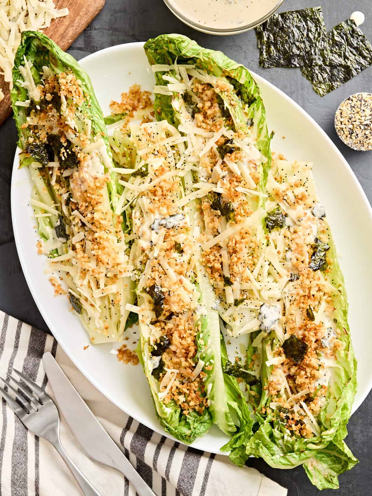 Overhead view of grilled romaine Caesar salad on a serving platter.
