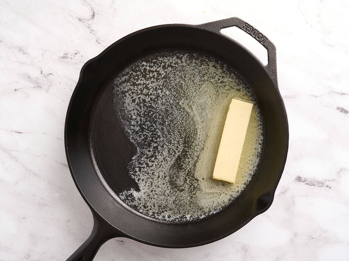 A stick of butter melting in a skillet.
