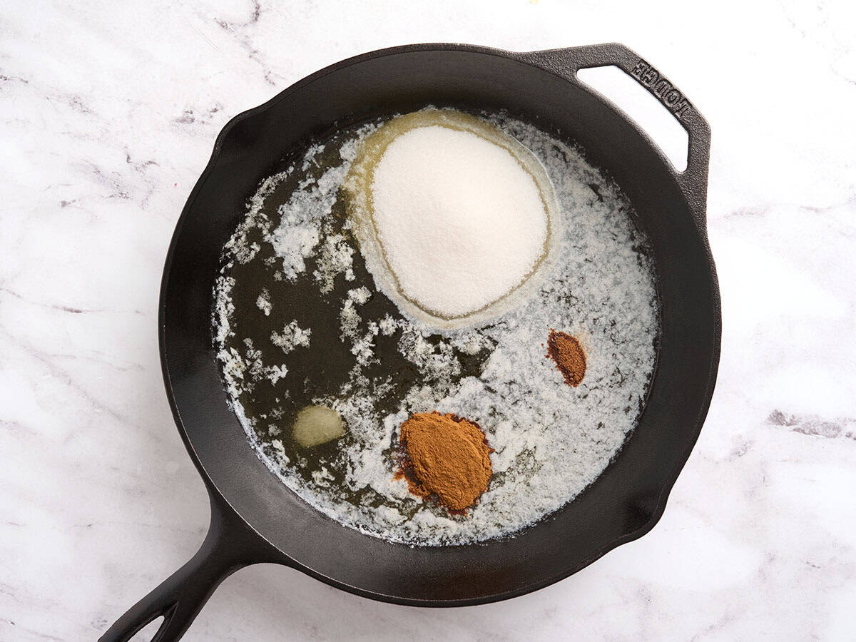 White sugar, cinnamon, nutmeg and salt added to a skillet of melted butter.