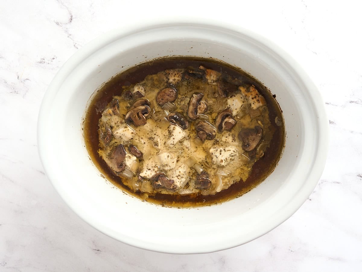 Chicken breasts and mushrooms in a crockpot after cooking for 4 hours.