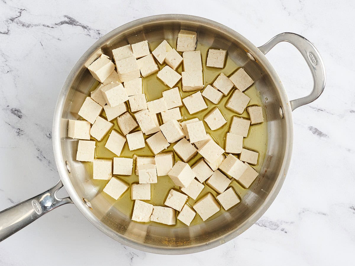 Firm tofu cubes in a skillet.