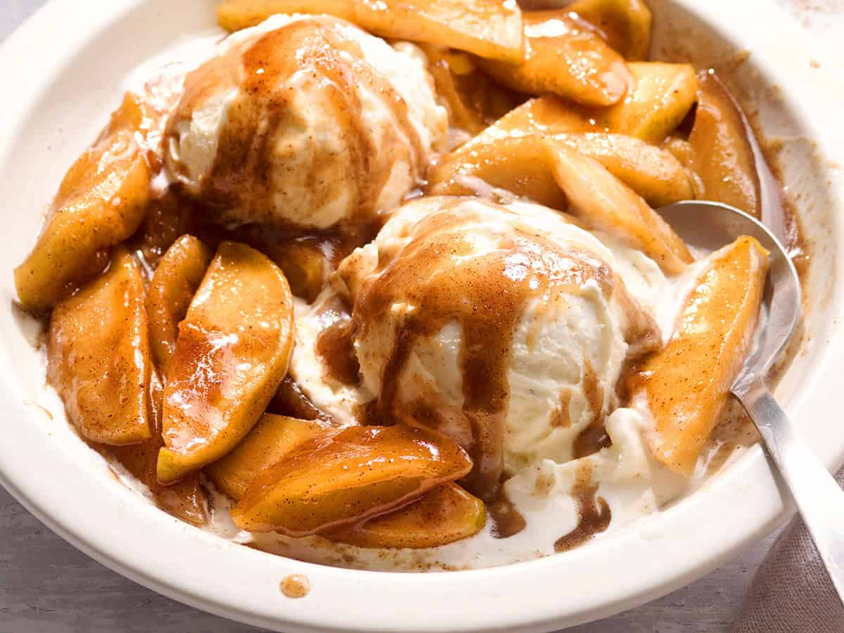 Overhead side view of fried apples and ice cream in a bowl.
