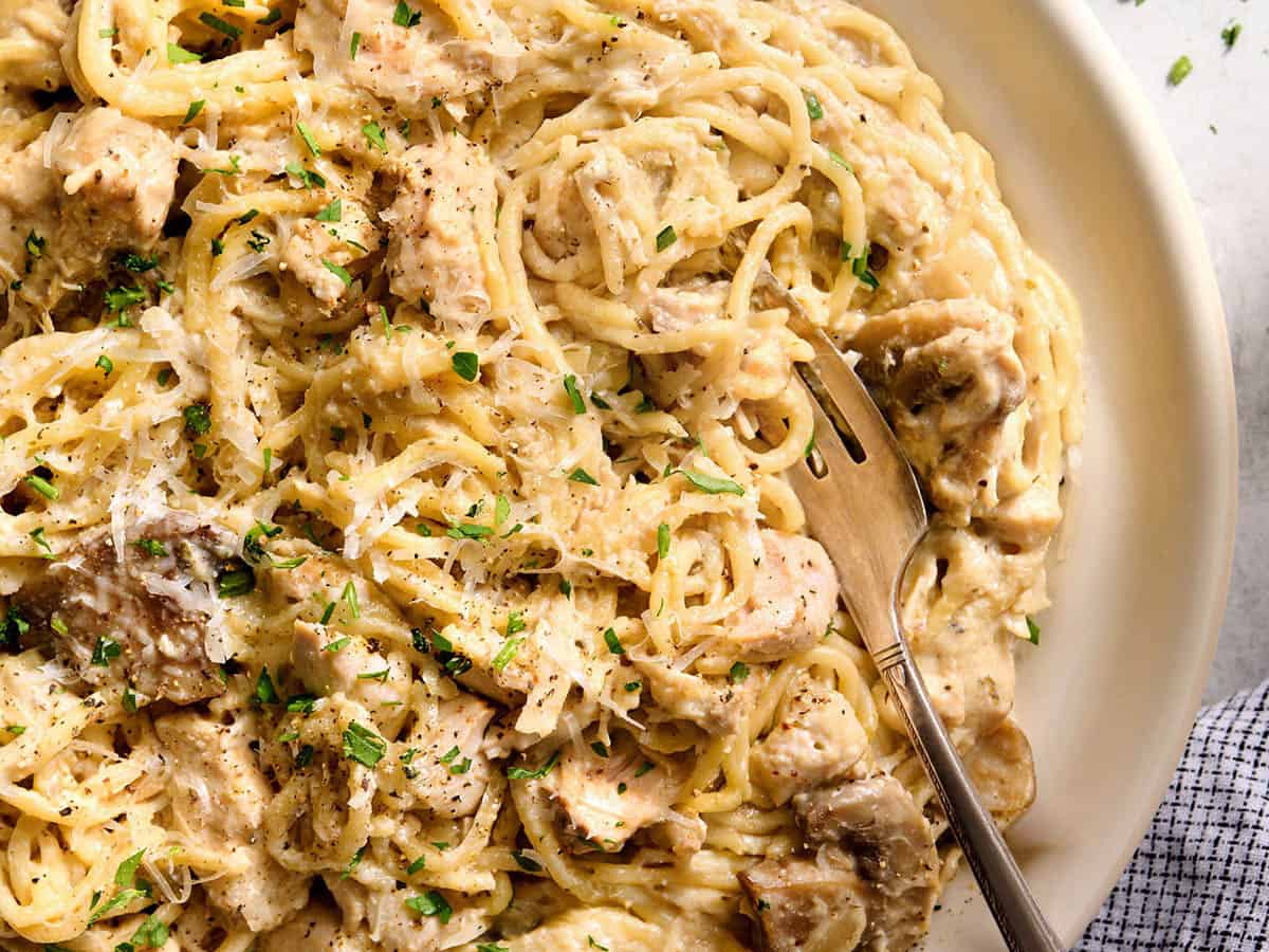 Overhead close up view of a plate of crockpot chicken tetrazzini with a fork.