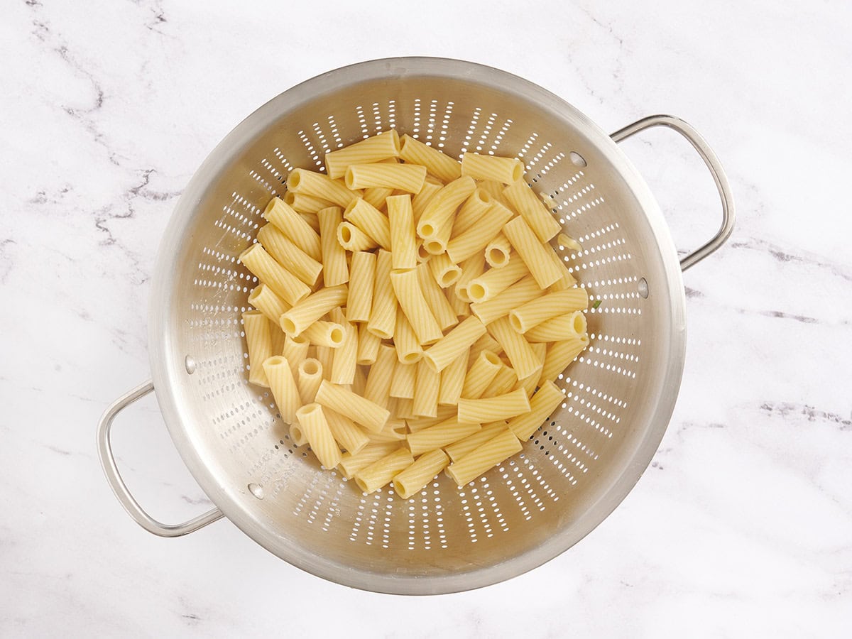Cooked rigatoni pasta in a colander.