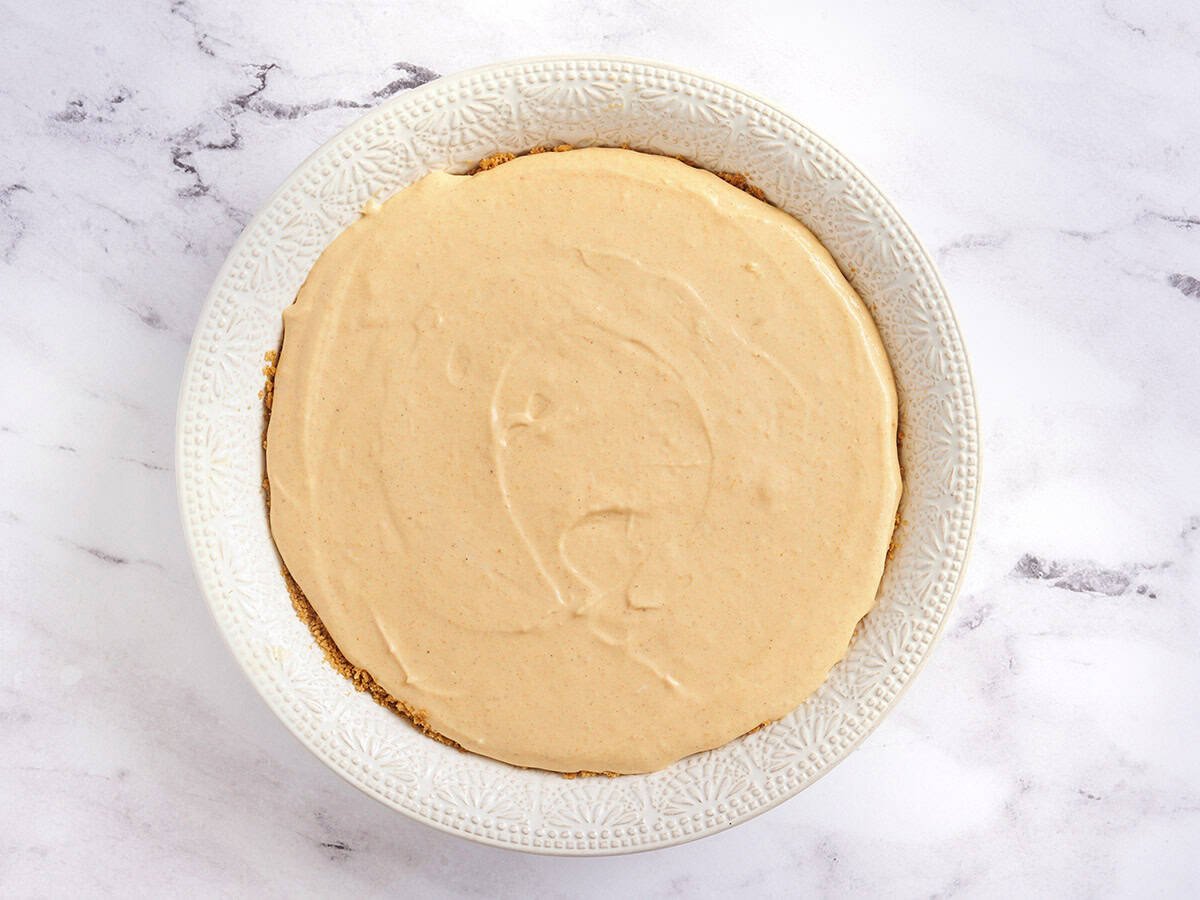 Pumpkin cheesecake in a pie dish before baking.