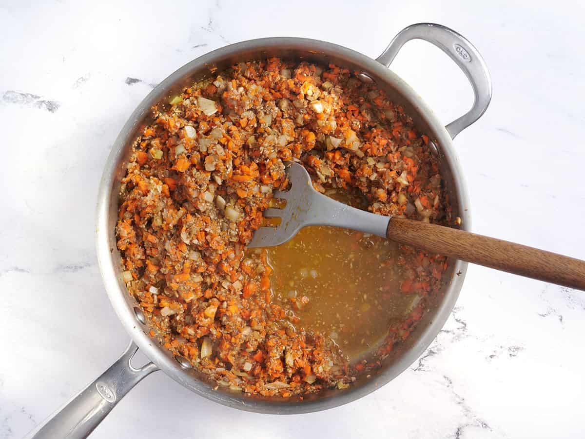 Lentil meatloaf ingredients in a saute pan with a spatula.