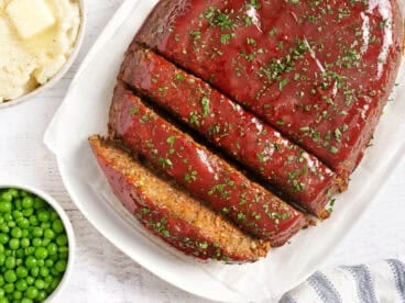 Overhead view of of a vegetarian lentil meatloaf with half cut into slices.