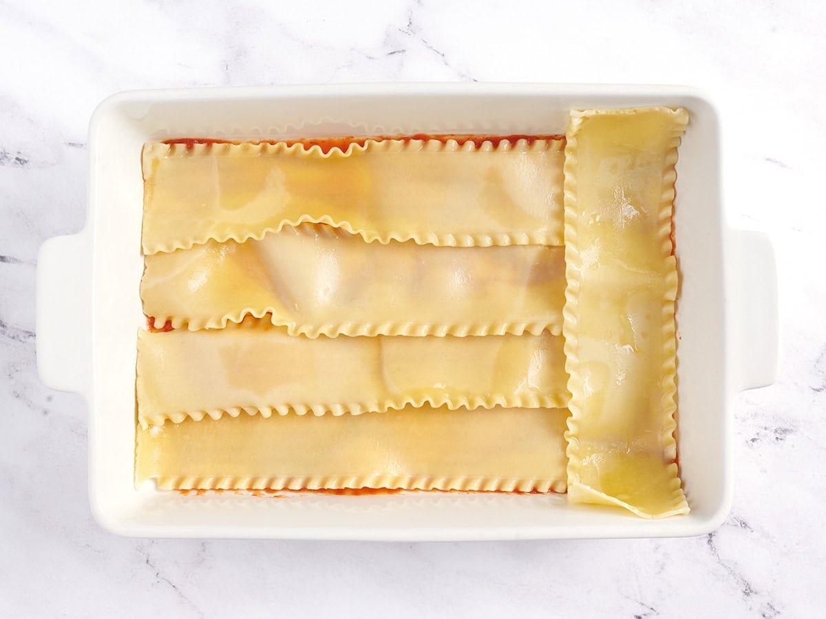 Cooked lasagna noodles added to the bottom of a casserole dish.