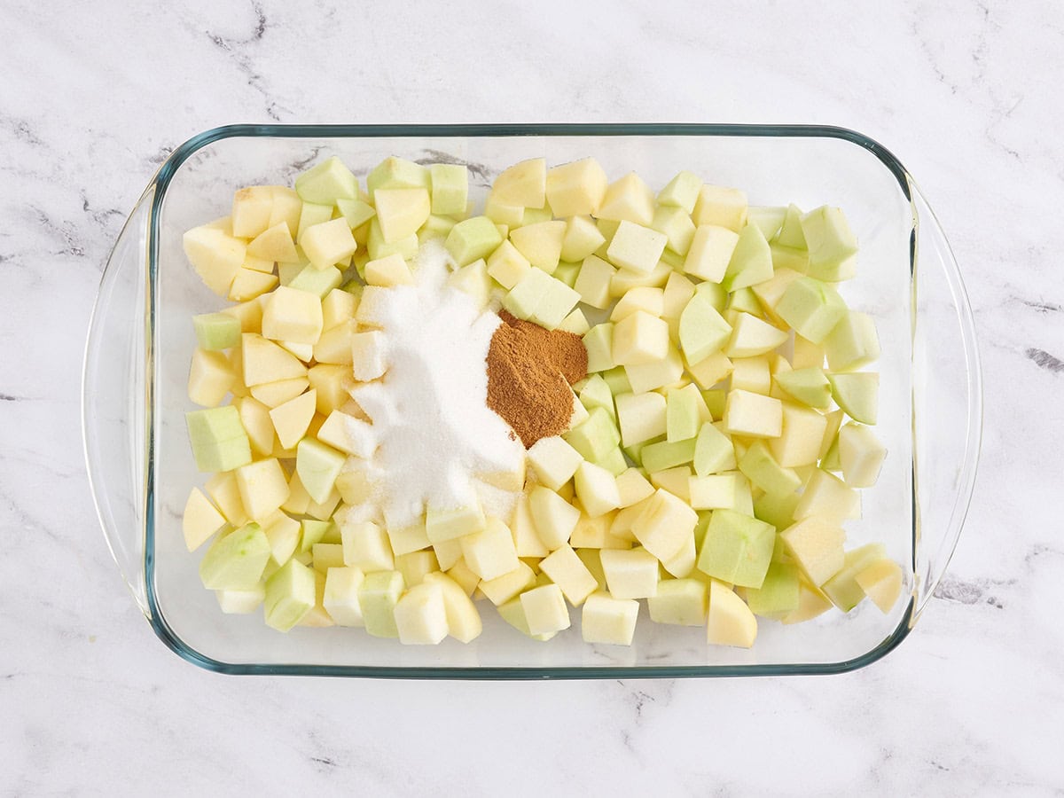 Diced apples with seasonings in a baking dish.