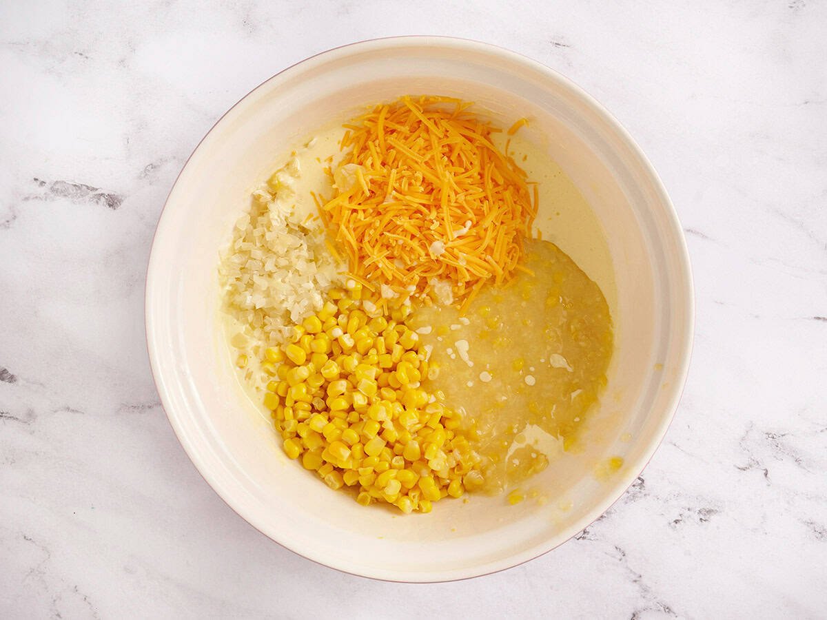 Add canned corn, cheese and onion to the yogurt/egg bowl.