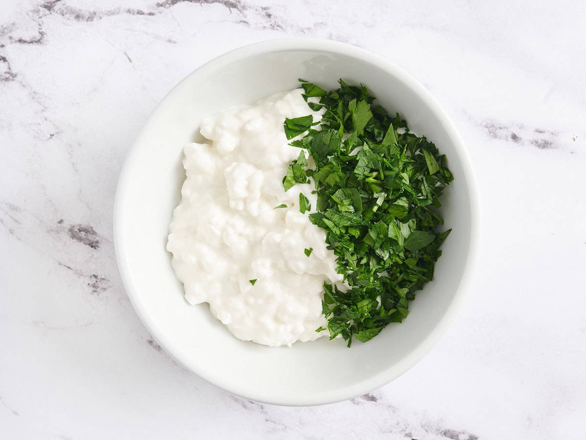 Cottage cheese and parsley in a bowl.