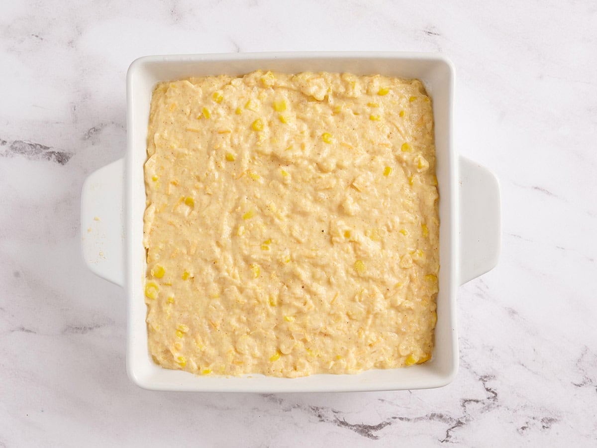Cornbread dough in a white baking dish.