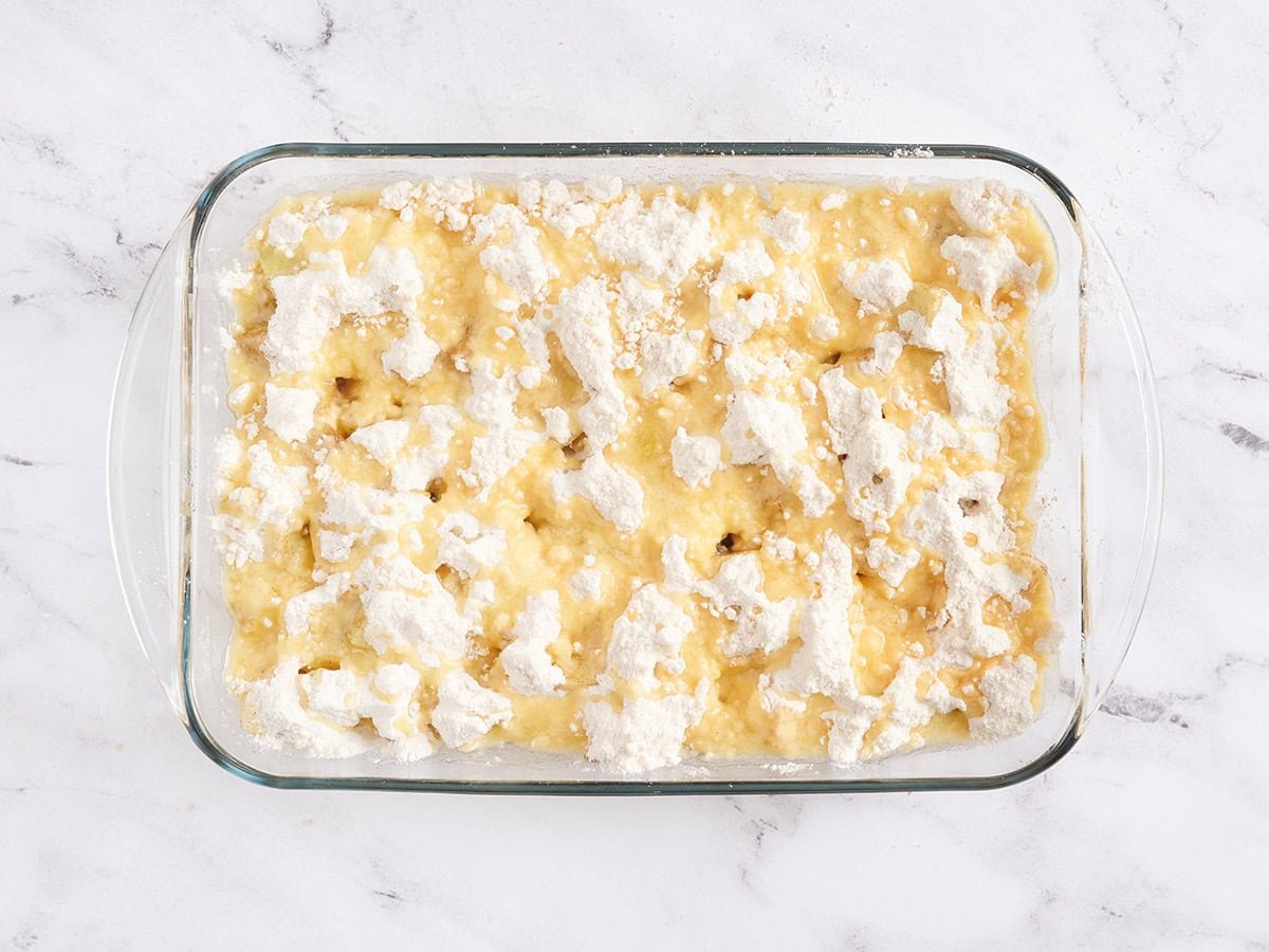 An apple dump cake in a baking dish before baking.