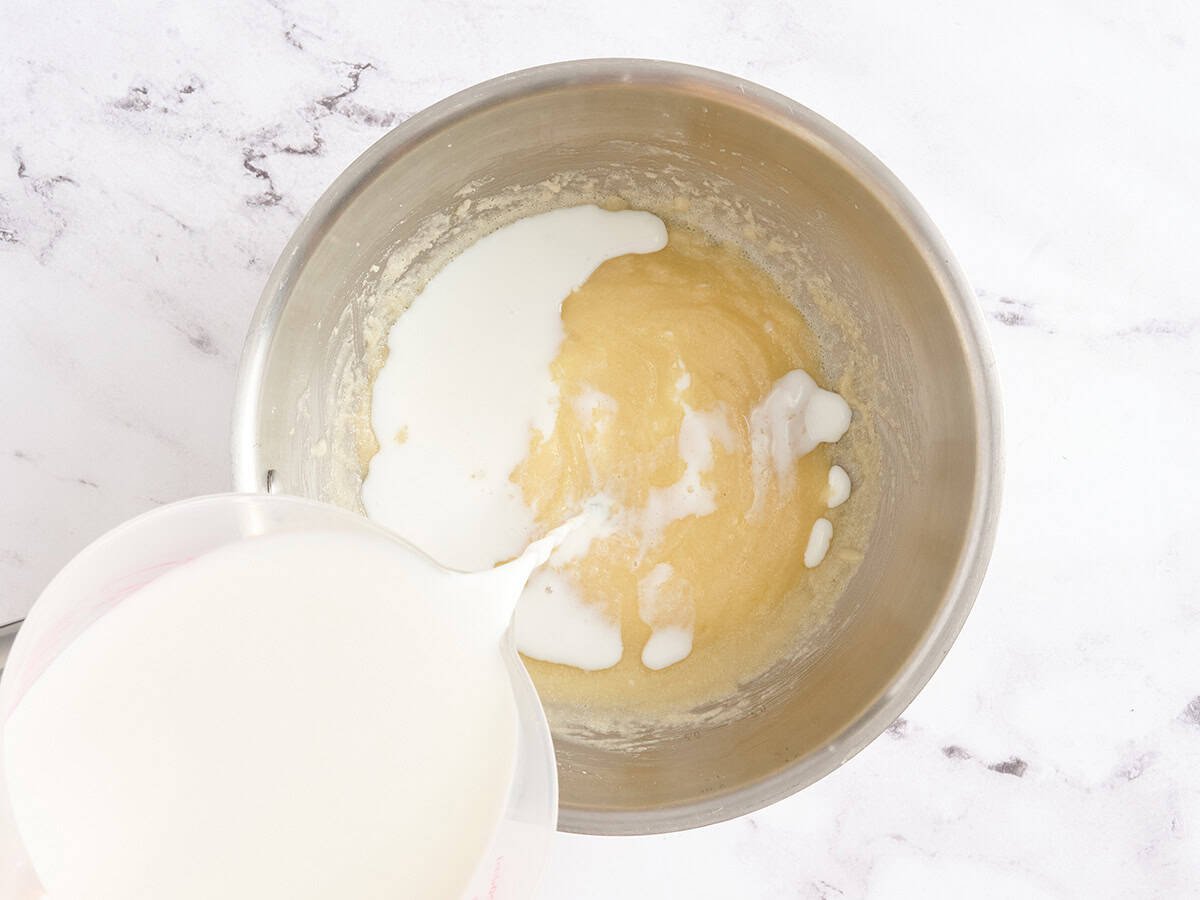 Milk being slowly poured into a roux.