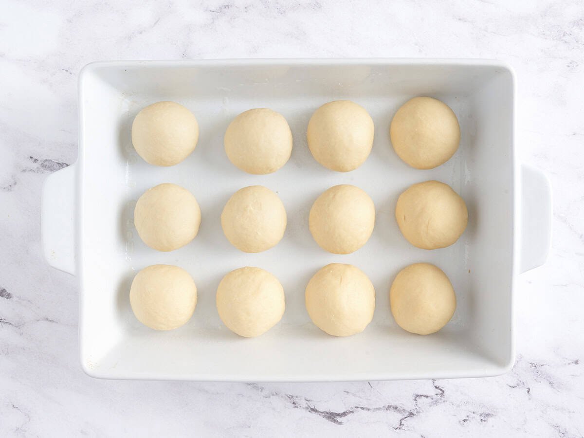 Portioned dough balls in a white baking dish.