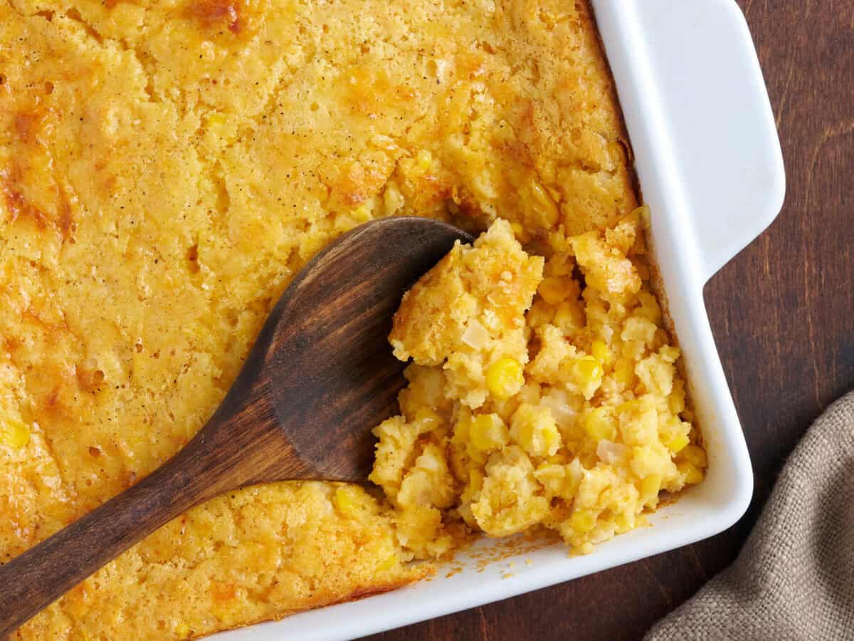 Wooden spoon in cornbread casserole.