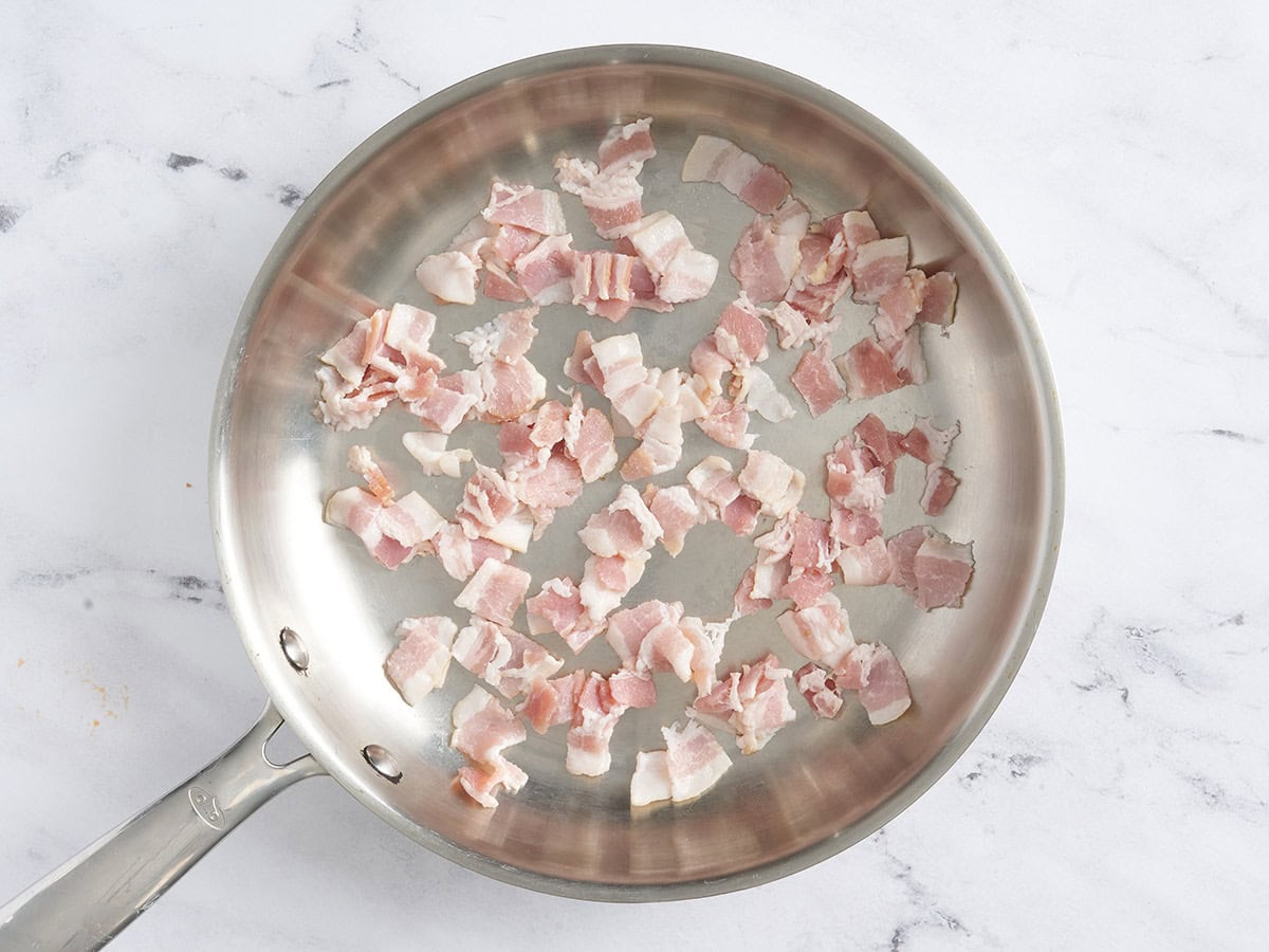 Pieces of bacon in a skillet.