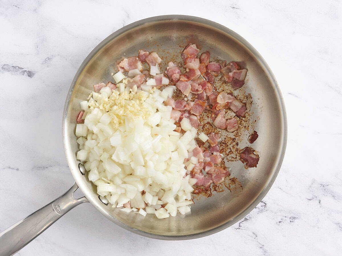 Onions and garlic added to the pot with the bacon.