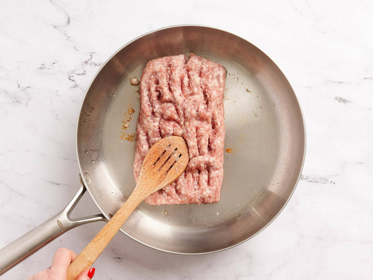 Ground pork in a skillet.
