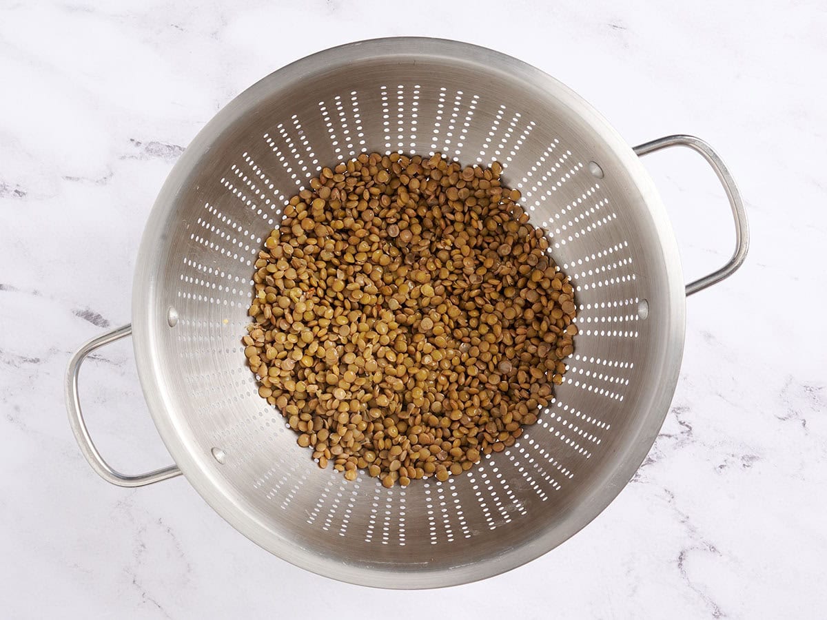 Cooked lentils in a colander.