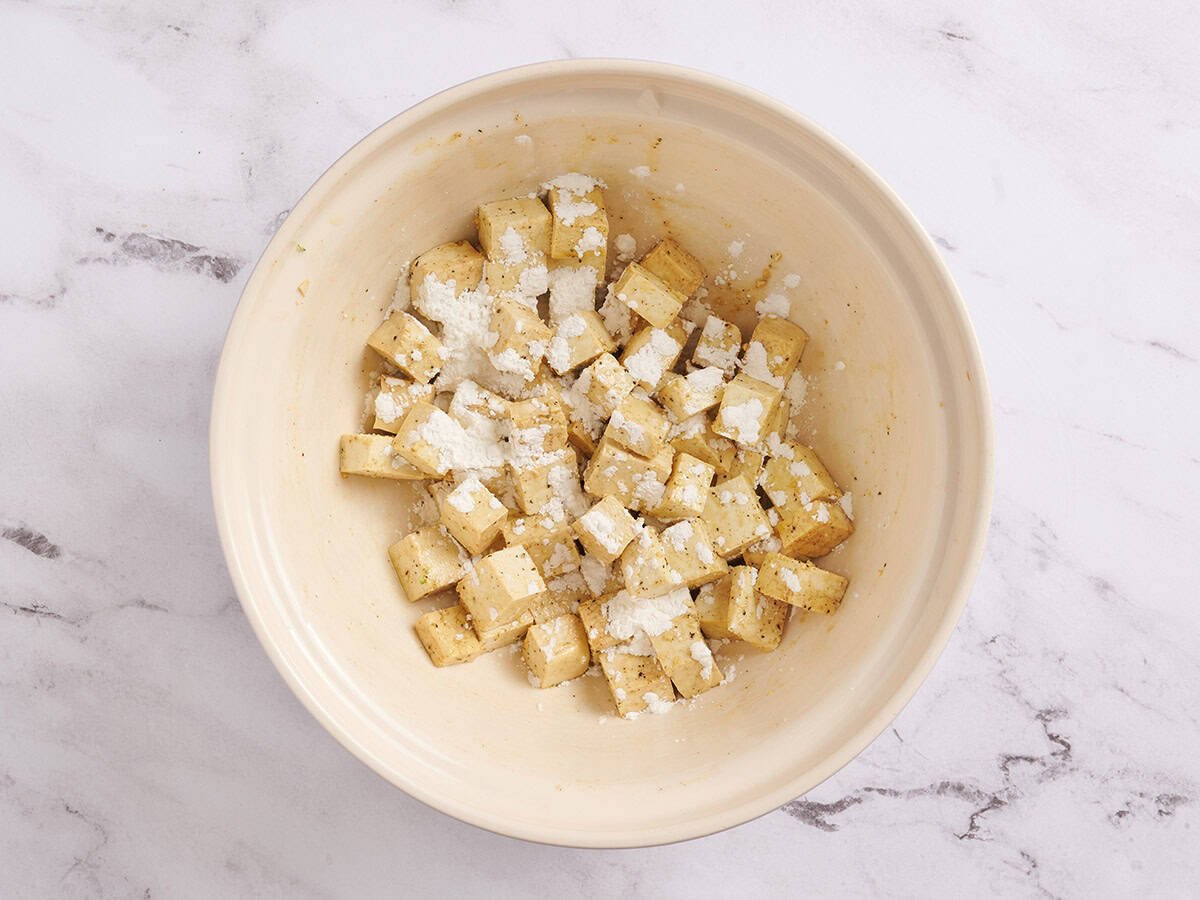 Seasoned tofu cubes sprinkled with cornstarch.