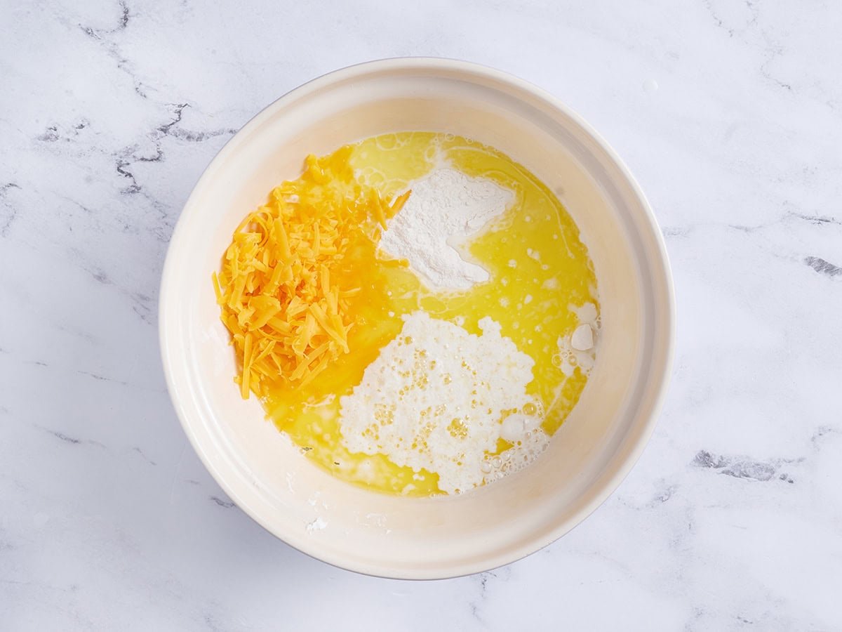 Flour, melted butter, and cheese in a bowl.