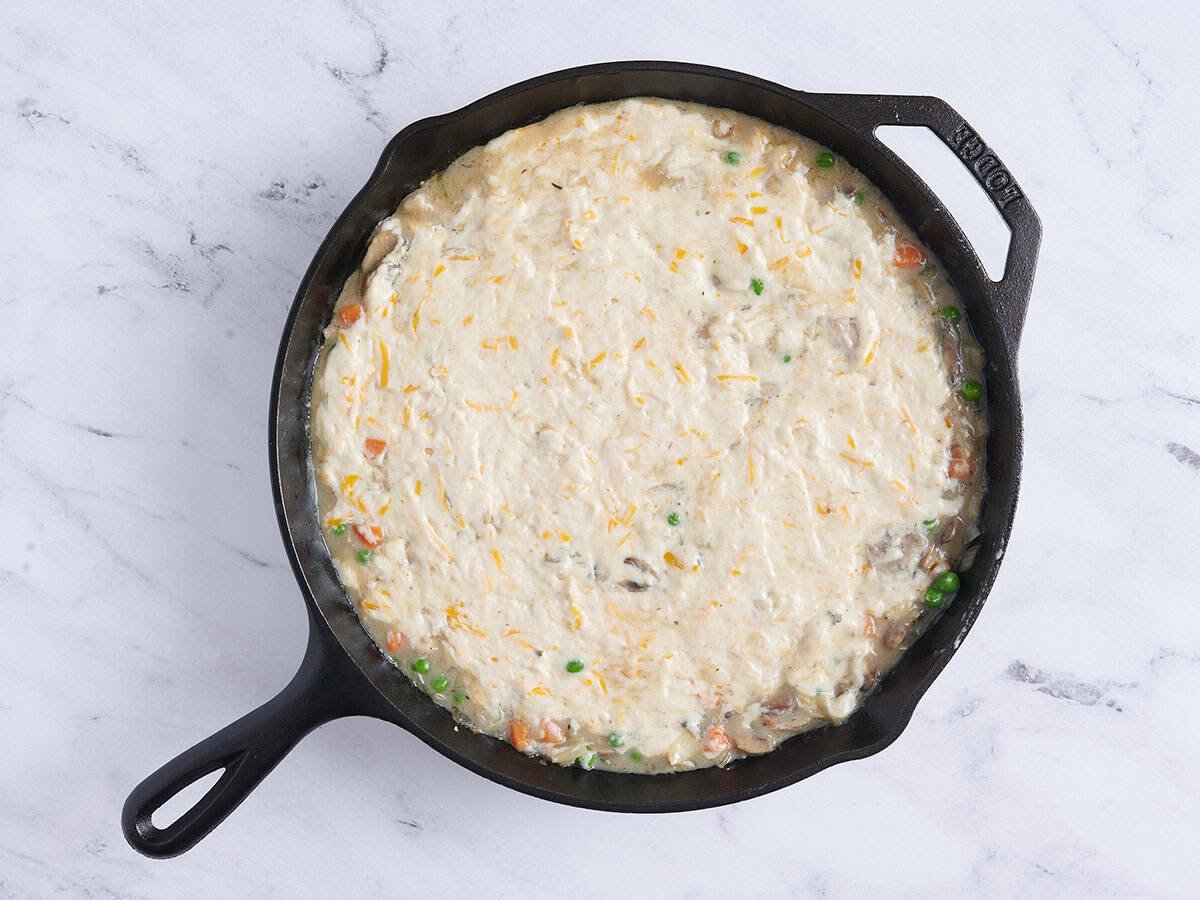 Chicken cobbler in a skillet before baking.