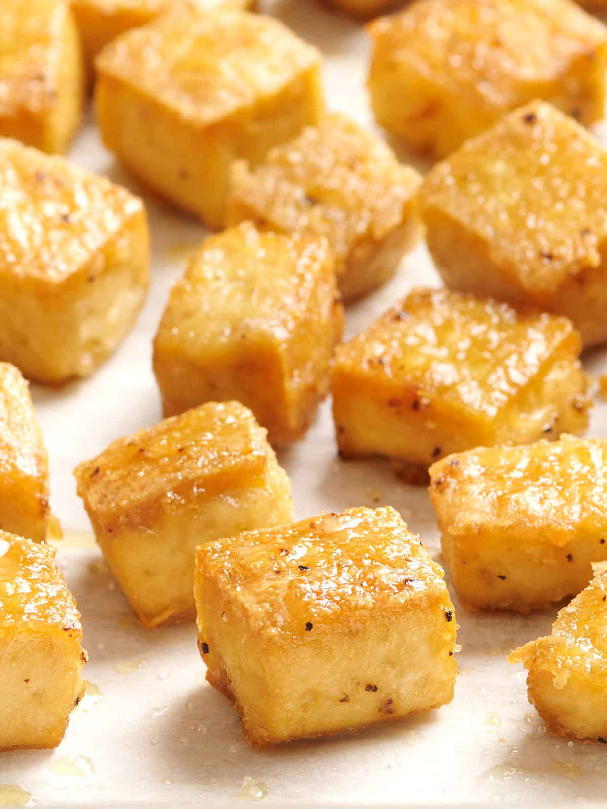 Side view of golden baked tofu cubes.
