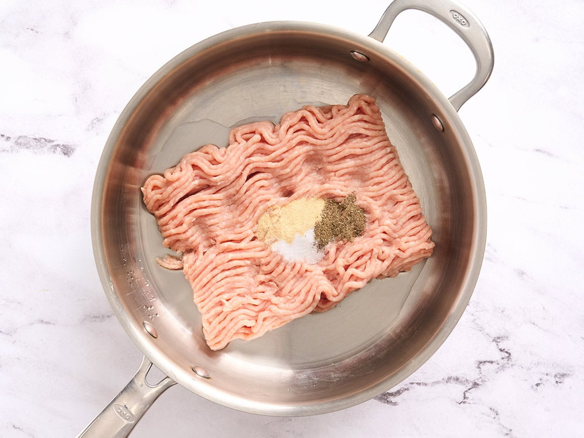 Ground chicken and seasonings in a skillet.