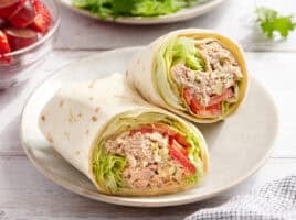 A tuna wrap sliced in half on a plate.