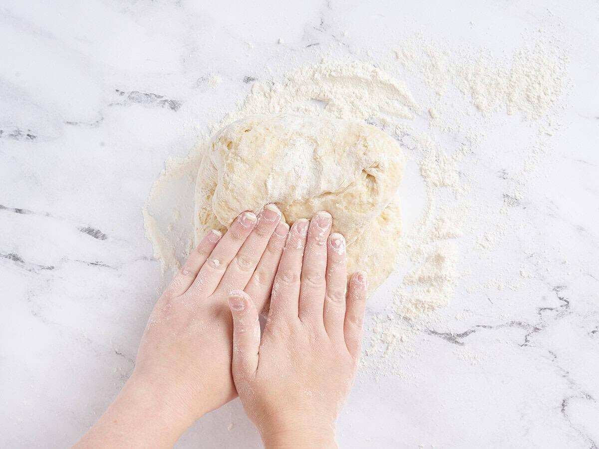 Kneading the dough on a floured countertop.