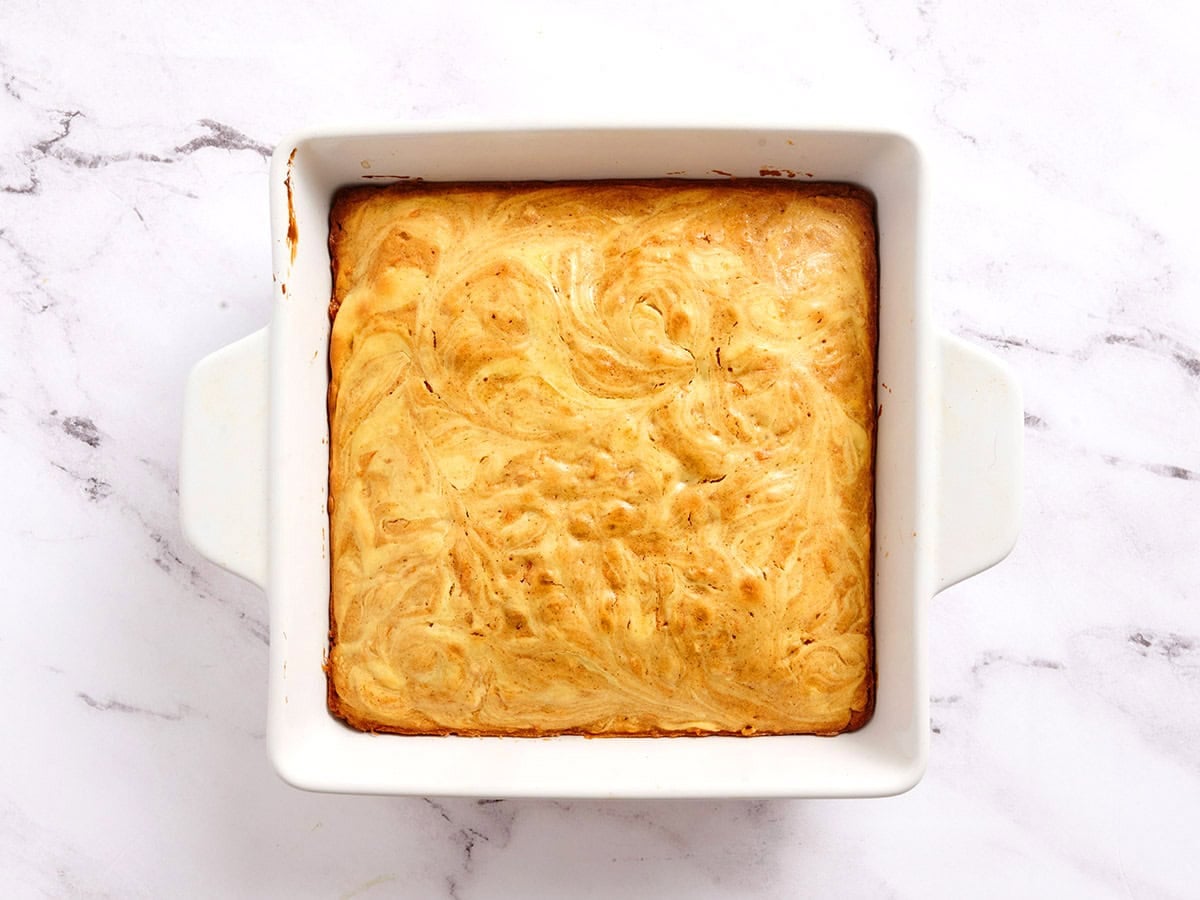 Finished carrot cake bars in a baking dish before slicing.