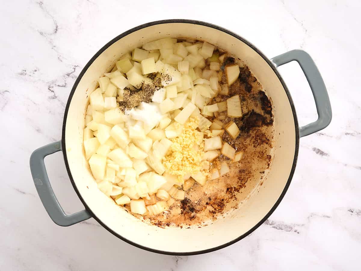 Onion and seasonings cooking in a dutch oven.