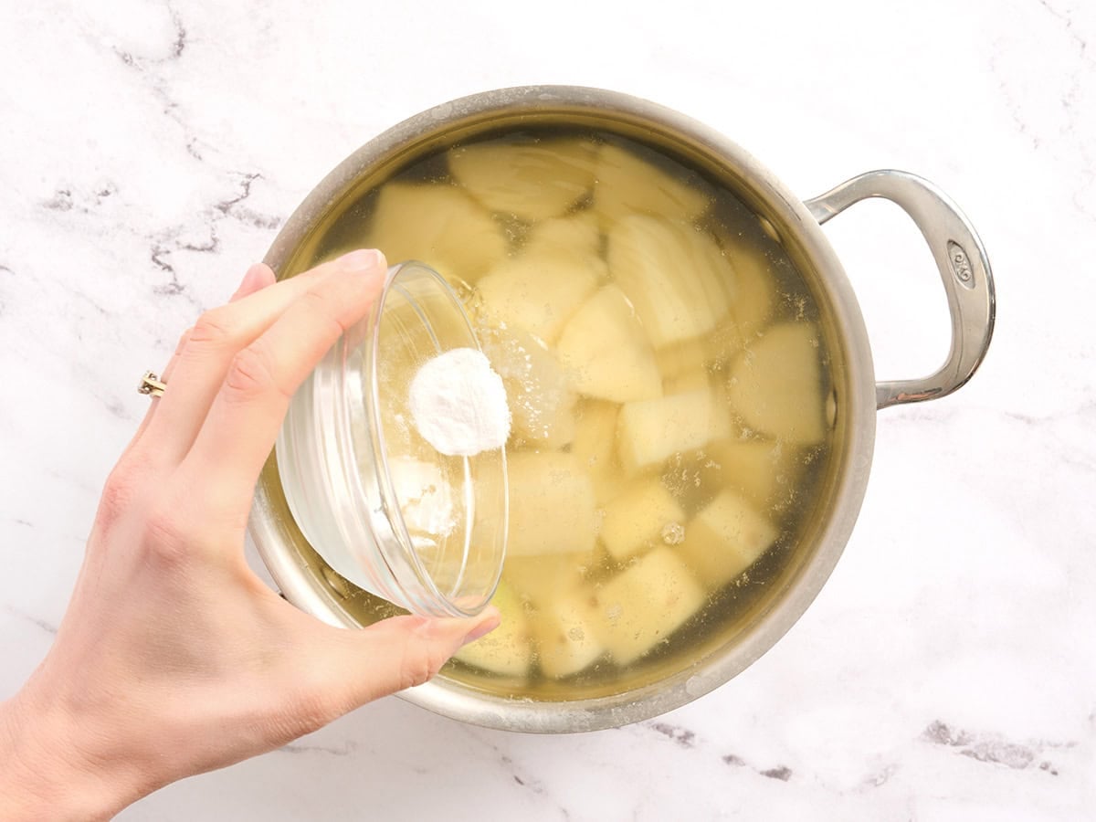 Baking soda added to a pot of diced potatoes.