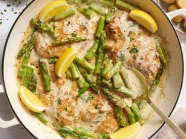 Overhead view of creamy asparagus chicken in a skillet.